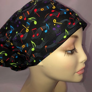 May include: A black scrub hat with a colorful musical note pattern. The hat is made of a soft, comfortable fabric and is perfect for nurses, doctors, and other healthcare professionals.