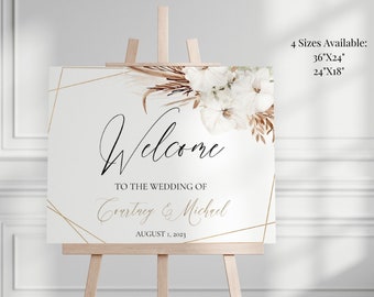 May include: Welcome sign for a wedding with a white background, gold geometric shapes, and a floral design with dried pampas grass. The text reads "Welcome to the wedding of Courtney & Michael August 1, 2023".