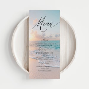 Pu&ograve; includere: Un menu a tema spiaggia con un tramonto sull'oceano come sfondo. Il menu elenca "Antipasto", "Insalata di spinaci e fragole con noci pecan candite", "Piatto principale", "Pollo al rosmarino con patate arrosto e carote", "Ravioli di ricotta al basilico con spinaci e salsa rossa", "Dessert", "Torta al tartufo al cioccolato e lamponi" e "Biscotti assortiti".