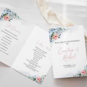 Könnte beinhalten: Hochzeitszeremonie-Programm mit einem floralen Design mit blauen und rosa Blumen. Das Programm enthält die Reihenfolge der Ereignisse für die Zeremonie und die Hochzeitsgesellschaft. Der Text auf dem Programm lautet "Die Zeremonie" und "Hochzeitsgesellschaft".
