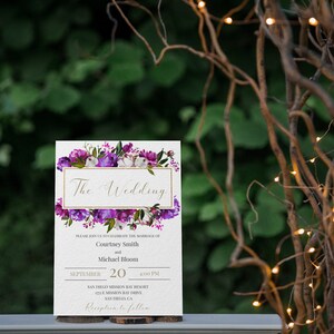 May include: A wedding invitation with purple and white floral designs. The text reads "The Wedding" and includes the names Courtney Smith and Michael Bloom, the date September 20, the time 4:00 PM, and the location San Diego Mission Bay Resort. The invitation also includes the text "Reception to follow".