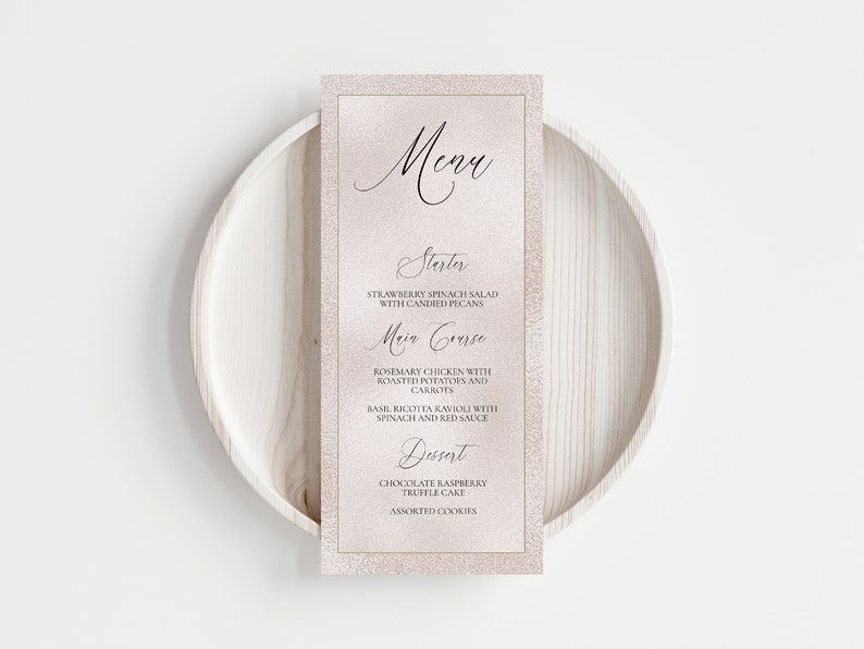 K&ouml;nnte beinhalten: Eine rosa und goldene Speisekarte mit dem Wort "Menu" in Kursivschrift. Die Speisekarte listet einen Vorspeise, ein Hauptgericht und ein Dessert auf. Die Vorspeise ist ein Erdbeer-Spinat-Salat mit kandierten Pekann&uuml;ssen. Das Hauptgericht ist Rosmarin-H&uuml;hnchen mit Bratkartoffeln und Karotten, Basilikum-Ricotta-Ravioli mit Spinat und roter Sauce. Das Dessert ist Schokoladen-Himbeer-Tr&uuml;ffelkuchen und verschiedene Kekse.