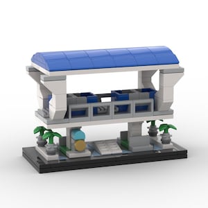 May include: A miniature Lego model of a modern transit station. The station features a blue roof, white supports, and gray platforms. Green plants and a black base complete the design. The model is a creative representation of a public transportation hub.