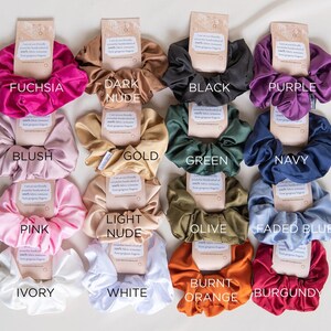 May include: A set of 14 scrunchies in various colors, including fuchsia, dark nude, black, purple, blush, gold, green, navy, pink, light nude, olive, faded blue, burnt orange, and burgundy.