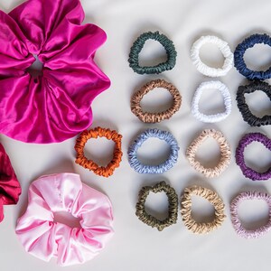 May include: A set of 15 colorful satin scrunchies in various colors, including pink, red, white, brown, blue, green, and purple. The scrunchies are arranged in a grid pattern on a white background.