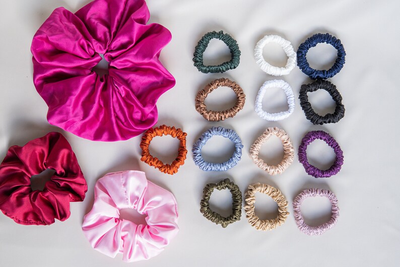May include: A set of 15 colorful satin scrunchies in various colors, including pink, red, white, brown, blue, green, and purple. The scrunchies are arranged in a grid pattern on a white background.