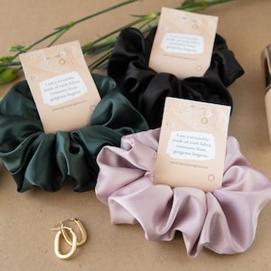 Può includere: Tre scrunchies di seta in verde, nero e rosa, con un piccolo biglietto che recita "Sono uno scrunchie fatto di tessuto di seta proveniente da resti di lingerie splendida www.identtyinglingerie.com".