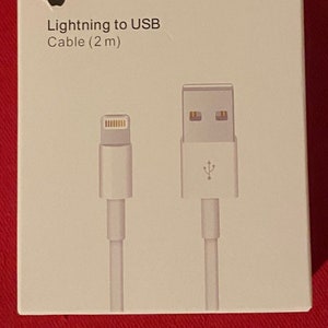 Può includere: Una confezione da tre cavi Apple Lightning a USB bianchi, ognuno lungo 2 metri. I cavi hanno un connettore Lightning bianco a un'estremità e un connettore USB bianco all'altra estremità. La confezione è bianca con il logo Apple e il testo "Lightning to USB Cable (2 m)".