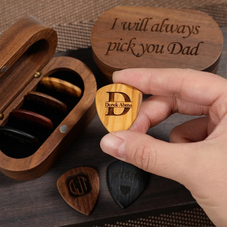 a person holding a wooden guitar pick in their hand
