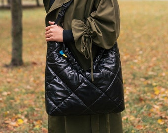 Black waterproof crossbody bag. Ideal glossy nylon crossbody bag for rainy weather has 3 pockets, quilted and lightweight.