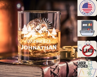 May include: A personalized whiskey glass with a mountain scene and the date 07.28.2023 and the name Johnathan etched on the front.