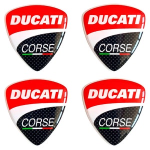 May include: Four red, white and black Ducati Corse stickers. Each sticker features the Ducati logo and the words "Corse" in green, white and red.