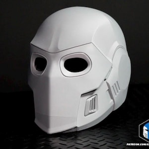 May include: A white, futuristic helmet with a smooth, matte finish. It has large eye openings, a prominent chin piece, and angular design elements. The overall aesthetic suggests a sci-fi or cosplay theme, with a sleek, modern look.