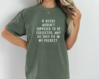 Könnte beinhalten: Ein grünes T-Shirt mit dem Text "IF ROCKS WEREN'T SUPPOSED TO BE COLLECTED, WHY DO THEY FIT IN MY POCKET?" in weiß gedruckt.