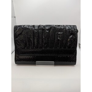 May include: A black rectangular clutch bag featuring a textured snakeskin pattern. The upper portion of the bag has a gathered, pleated design, while the lower section is smooth and flat. The bag has a structured flap closure across the front.