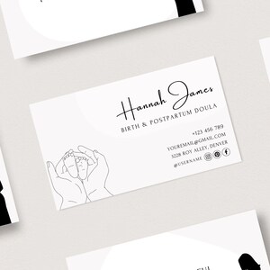Puede incluir: Tarjeta de visita en blanco y negro con un dibujo lineal simple de dos manos sosteniendo un par de pies de beb&eacute;. El texto en la tarjeta dice "Hannah James, Birth & Postpartum Doula".