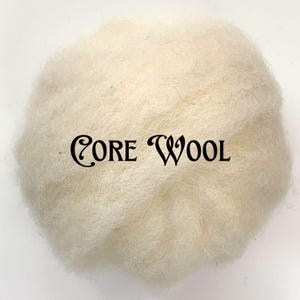May include: A close-up of a ball of off-white core wool. The wool is fluffy and textured, with the words "CORE WOOL" printed in black script across the center. The background is plain white.