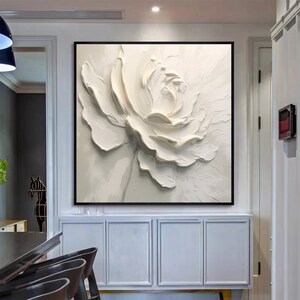 May include: A white 3D textured flower painting with a white background. The flower is in the center of the canvas and is the main focus of the painting.