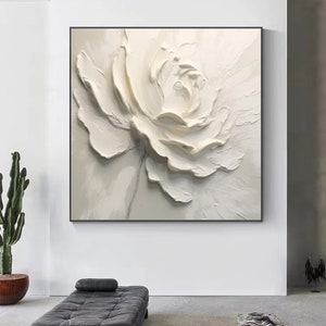 May include: A white flower painting with a textured, 3D effect. The flower is painted in shades of white and cream, with a subtle gray stem.