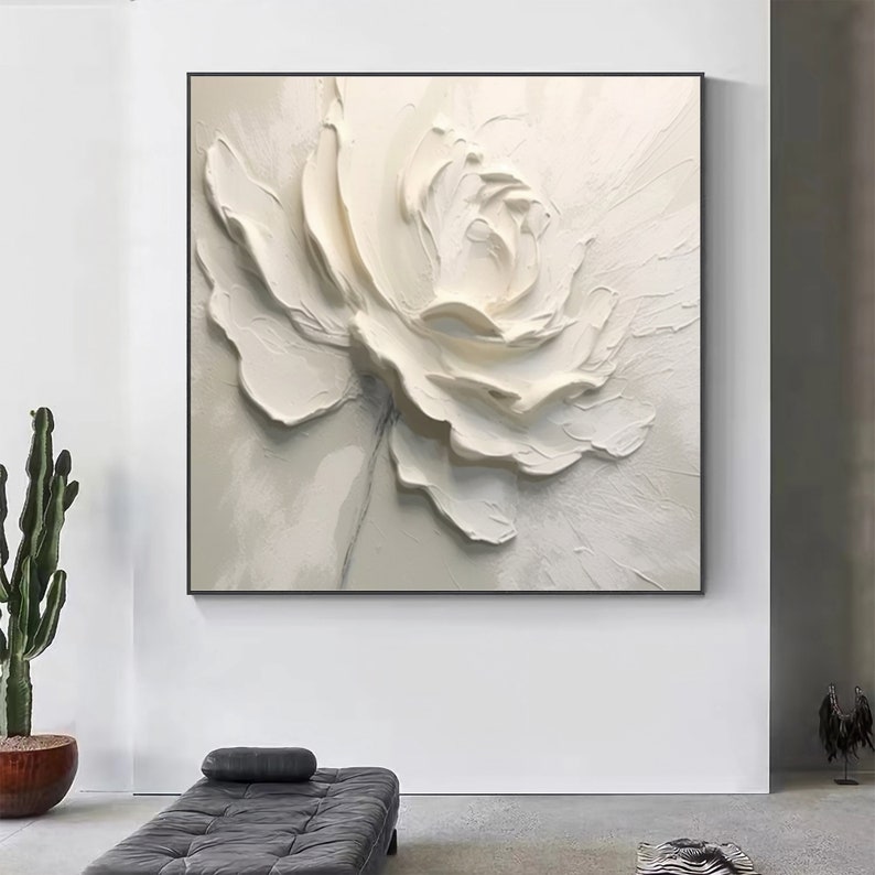 May include: A white flower painting with a textured, 3D effect. The flower is painted in shades of white and cream, with a subtle gray stem.