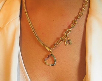 May include: A gold chain necklace with a heart-shaped pendant and a padlock charm. The heart pendant is decorated with colorful gemstones.
