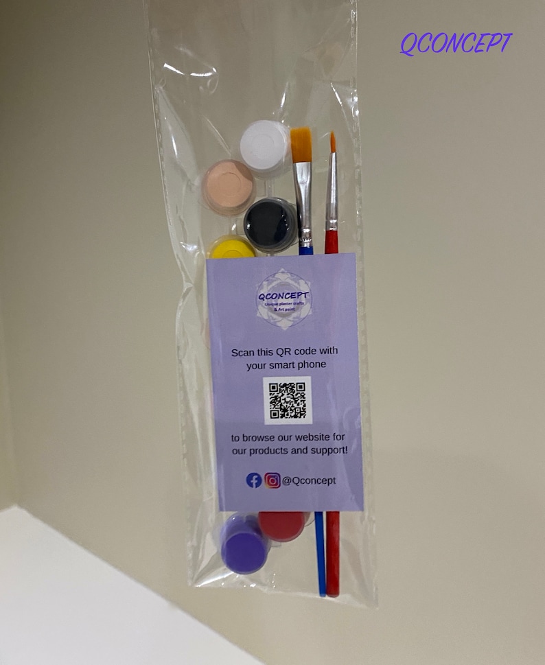 May include: A set of paint pots and brushes in a clear plastic bag. The paint pots are in various colours, including white, beige, black, and yellow. The bag also includes a small card with a QR code and the text "QCONCEPT Unique polymer crafts and art paint".