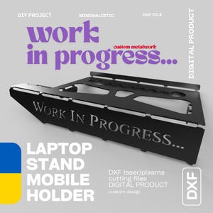 Könnte beinhalten: Ein Laptopständer aus schwarzem Metall mit lasergeschnittenem Design und dem Schriftzug "WORK IN PROGRESS..." auf der Vorderseite. Der Ständer verfügt über eine flache Oberfläche mit geometrischen Ausschnitten und eine erhöhte hintere Kante.