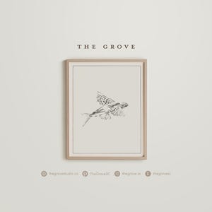 Puede incluir: Impresión artística enmarcada con una ilustración en blanco y negro de un pez volador. La obra de arte está sobre un fondo neutro y enmarcada en un tono de madera clara. El texto "THE GROVE" está en la parte superior.