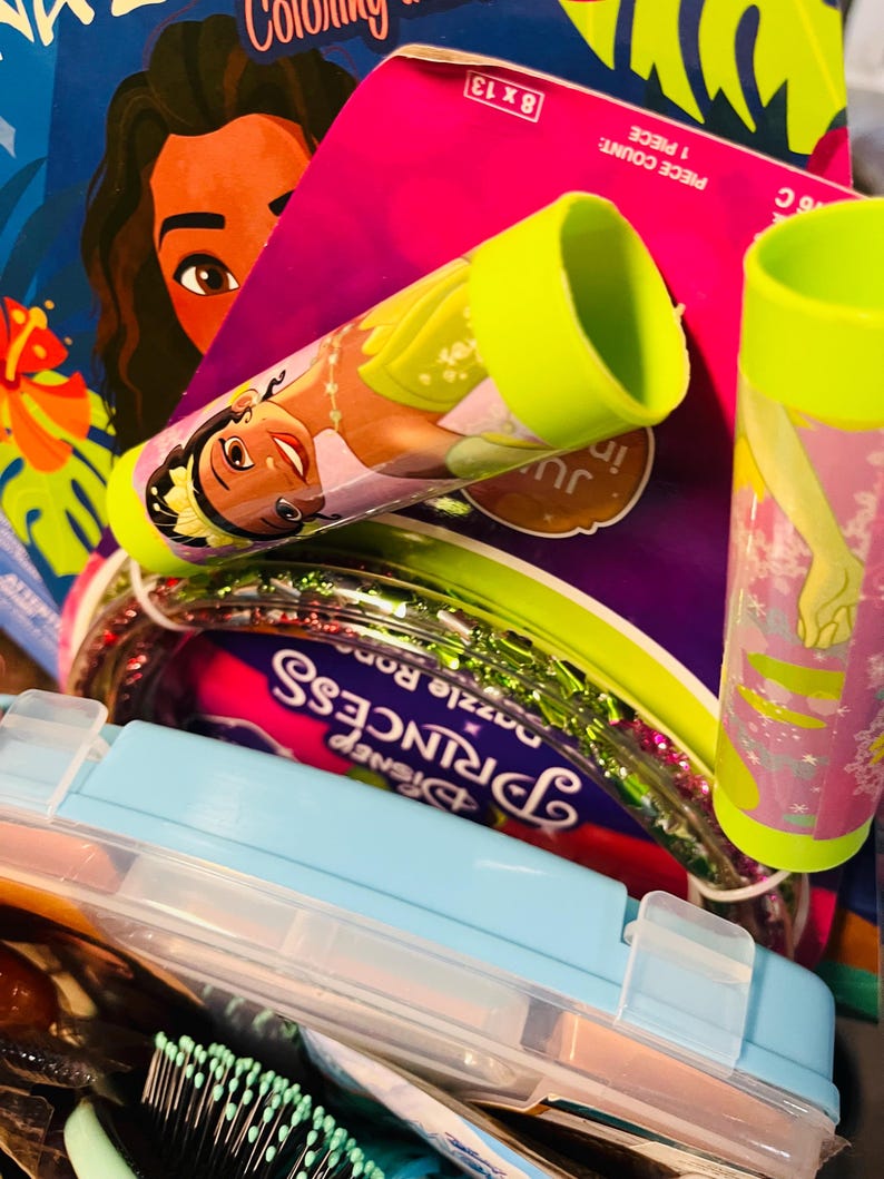 Puede incluir: Una colecci&oacute;n de art&iacute;culos para ni&ntilde;os, que incluye un libro para colorear con un personaje de dibujos animados, un estuche azul claro y varios tubos con dise&ntilde;os de princesas. Los tubos tienen tapas de color verde brillante.
