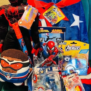 May include: A collection of Marvel Avengers merchandise, including a Spider-Man plush, a Captain America action figure, a coloring book, and lollipops. The items are arranged on a blue blanket with a white star.