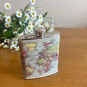 Een interessante vintage vintage fles van roestvrij staal met een wereldkaart erop. Verzamelsouvenir. Reizend drinkgerei. Cadeau voor hem.