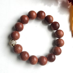 Natural orange Sandstone 12 mm beads elasticated bracelet with a quality gilded brass and rhinestones spacer bead. Handmade gift for her