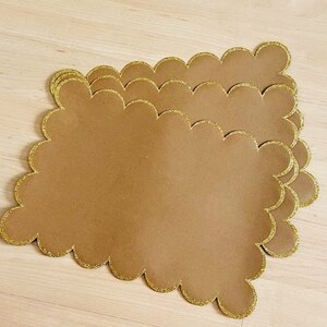 Peut inclure: Ensemble de quatre sets de table marrons avec un bord festonné et une bordure pailletée dorée.