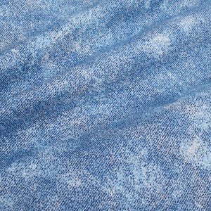Puede incluir: Primer plano de tela vaquera azul con un efecto desteñido blanqueado. La tela tiene un aspecto texturizado y tejido.
