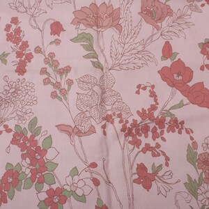 Pode incluir: Tecido rosa com um padr&atilde;o floral com flores e folhas vermelhas e verdes.