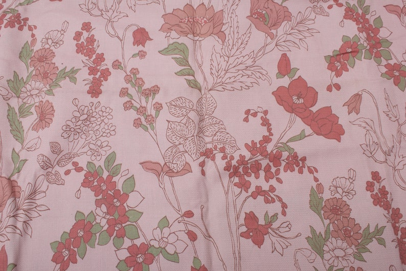 Pode incluir: Tecido rosa com um padr&atilde;o floral com flores e folhas vermelhas e verdes.
