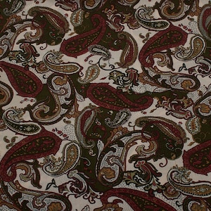 1970s Vintage viscose fabric dressmaking, paisley red green beige background