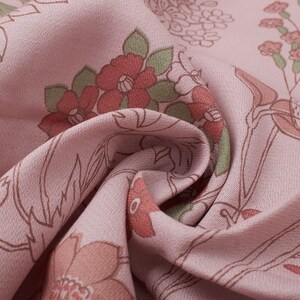 Pode incluir: Tecido rosa com estampa floral em tons de marrom e vermelho. O tecido est&aacute; dobrado e a estampa floral &eacute; vis&iacute;vel em ambos os lados da dobra.