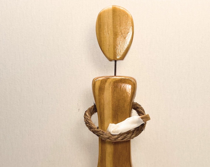 Faceless wood figurine of a mother holding her baby