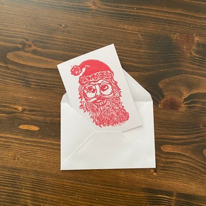 Tarjeta de felicitación navideña en linograbado con impresión en bloque en relieve hecha a mano de Papá Noel y renos (10,5 x 15 cm)