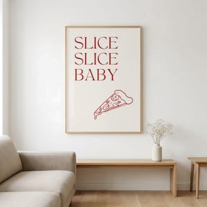 Könnte beinhalten: Ein gerahmter Druck mit den Worten "SLICE SLICE BABY" in roter Schrift. Darunter befindet sich eine rote Strichzeichnung einer Pizzaschnitte. Der Druck hängt an einer weißen Wand.