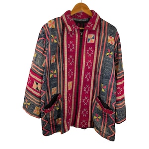 May include: A long-sleeved zip-up jacket featuring a vibrant patchwork design with alternating vertical panels of deep magenta and dark blue fabric. The garment is decorated with intricate white geometric embroidery and small square accents in yellow, orange, and pink.