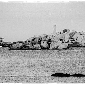 Fotografía en blanco y negro de la costa de Trégastel, a lo lejos el faro de Men Ruz en Ploumanach