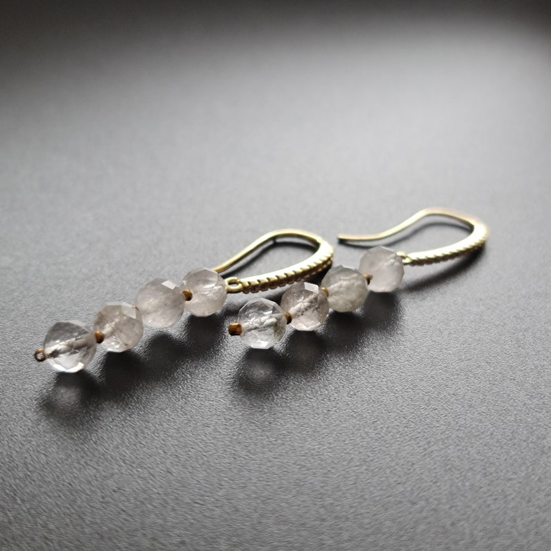 Pu&ograve; includere: Un paio di orecchini pendenti in oro con perle di quarzo trasparente. Gli orecchini hanno un design semplice e sono perfetti per l'uso quotidiano.