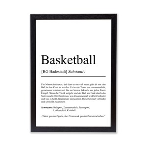 Könnte beinhalten: Ein gerahmter Druck mit dem Wort "Basketball" in großer, fetter, schwarzer Schrift. Darunter befindet sich eine deutsche Definition des Sports. Der Druck ist in einem schwarzen Rahmen.