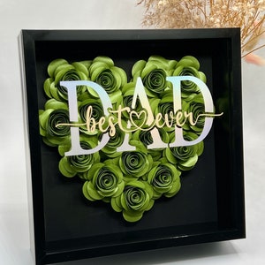 May include: A black framed shadow box with a green paper flower heart that spells out "DAD" with the words "best ever" in gold lettering.