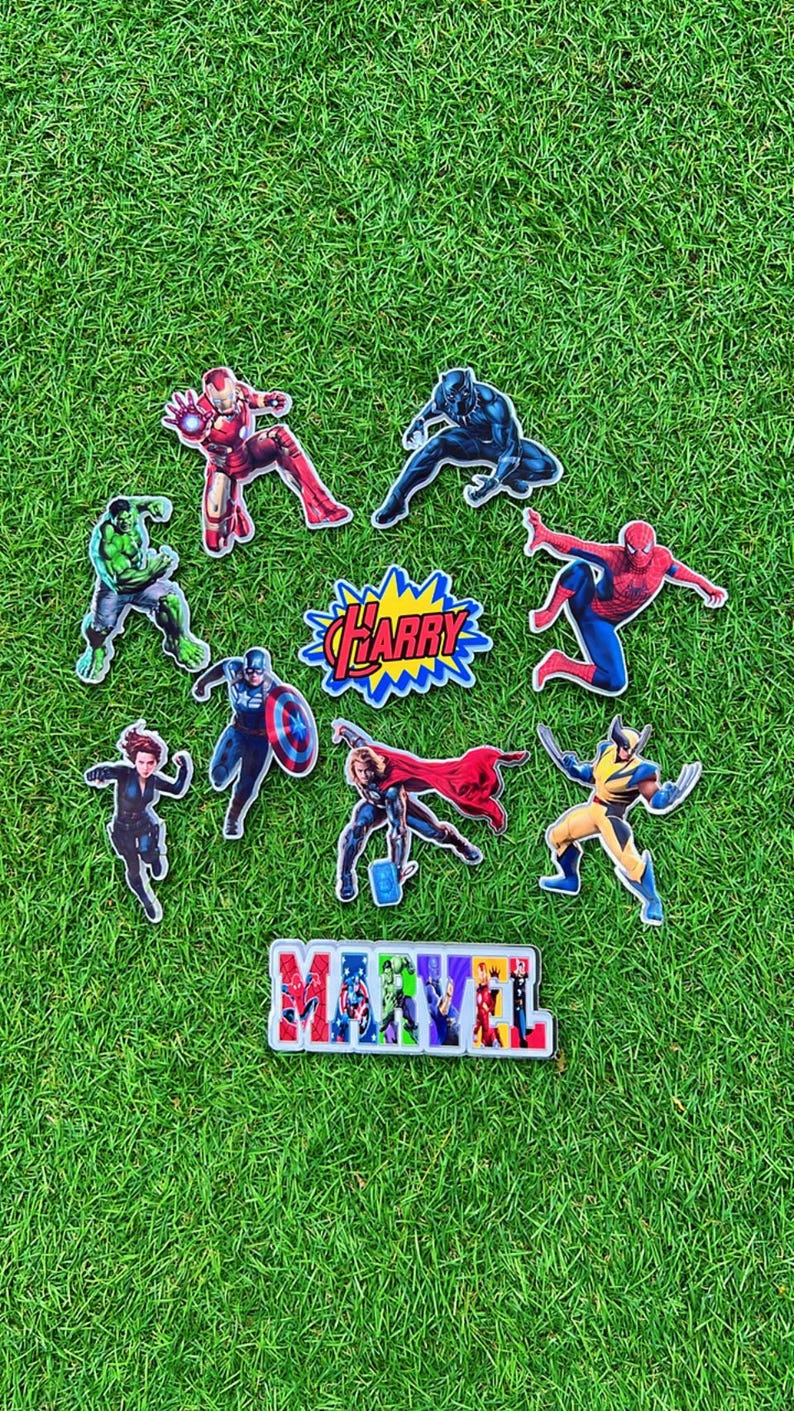Puede incluir: Una colecci&oacute;n de pegatinas de personajes de superh&eacute;roes de Marvel, incluyendo Iron Man, Black Panther, Hulk, Capit&aacute;n Am&eacute;rica, Thor, Wolverine y Spider-Man, dispuestas sobre una superficie de hierba verde. Las pegatinas presentan el logo de Marvel y el nombre "Harry".