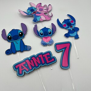 Puede incluir: Conjunto de seis adornos para tartas con tem&aacute;tica de Stitch, en azul y rosa. Los adornos representan a los personajes de Stitch y Angel de la pel&iacute;cula de Disney Lilo & Stitch. El conjunto incluye un n&uacute;mero 7, el nombre "ANNIE" y cuatro personajes de Stitch diferentes.