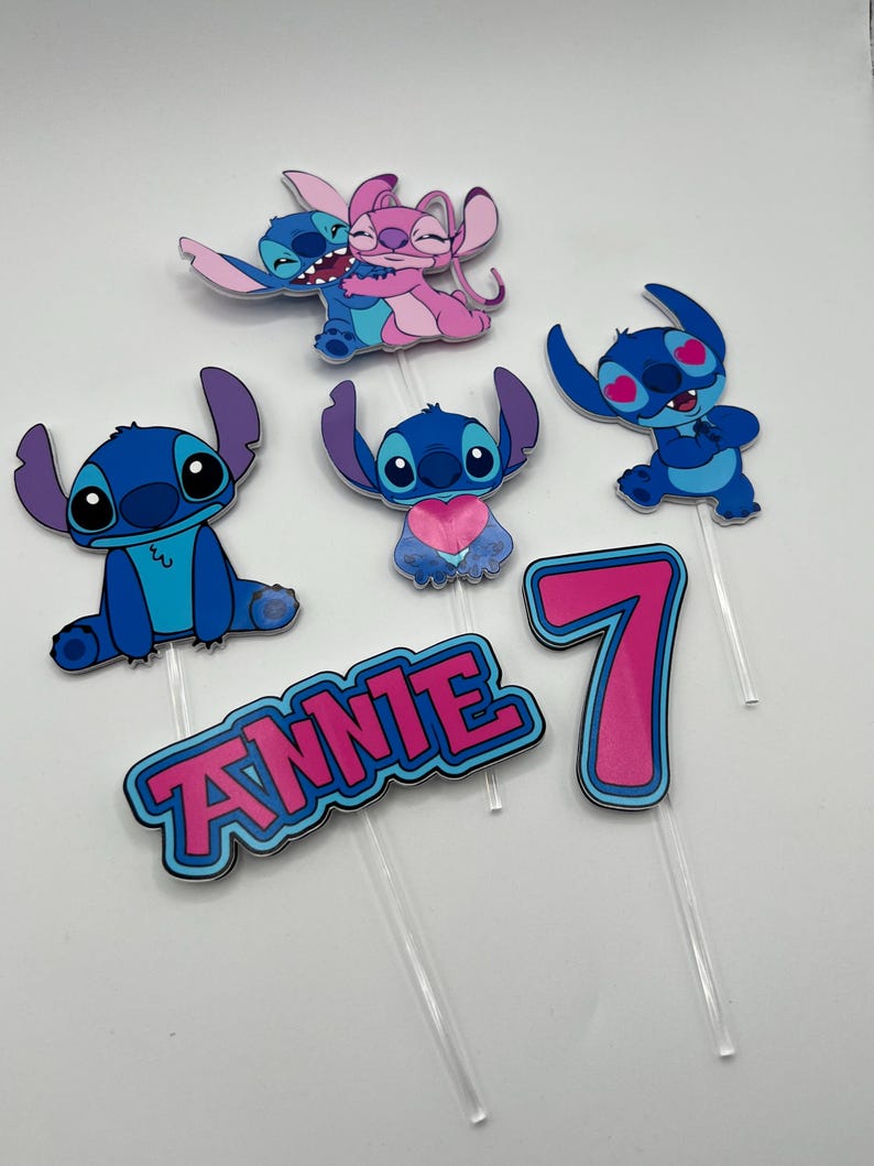 Puede incluir: Conjunto de seis adornos para tartas con tem&aacute;tica de Stitch, en azul y rosa. Los adornos representan a los personajes de Stitch y Angel de la pel&iacute;cula de Disney Lilo & Stitch. El conjunto incluye un n&uacute;mero 7, el nombre "ANNIE" y cuatro personajes de Stitch diferentes.