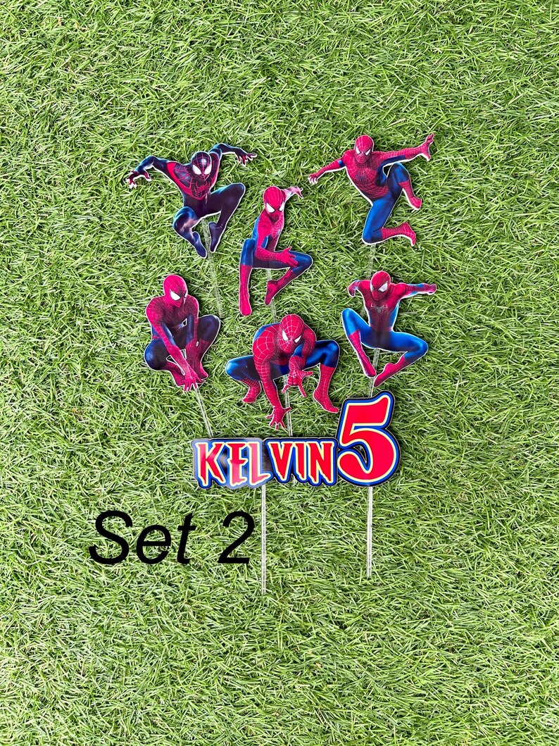 May include: Set of 7 red and blue Spiderman cake toppers with the name Kelvin and the number 5. The toppers are on sticks and are ready to be placed on a cake.